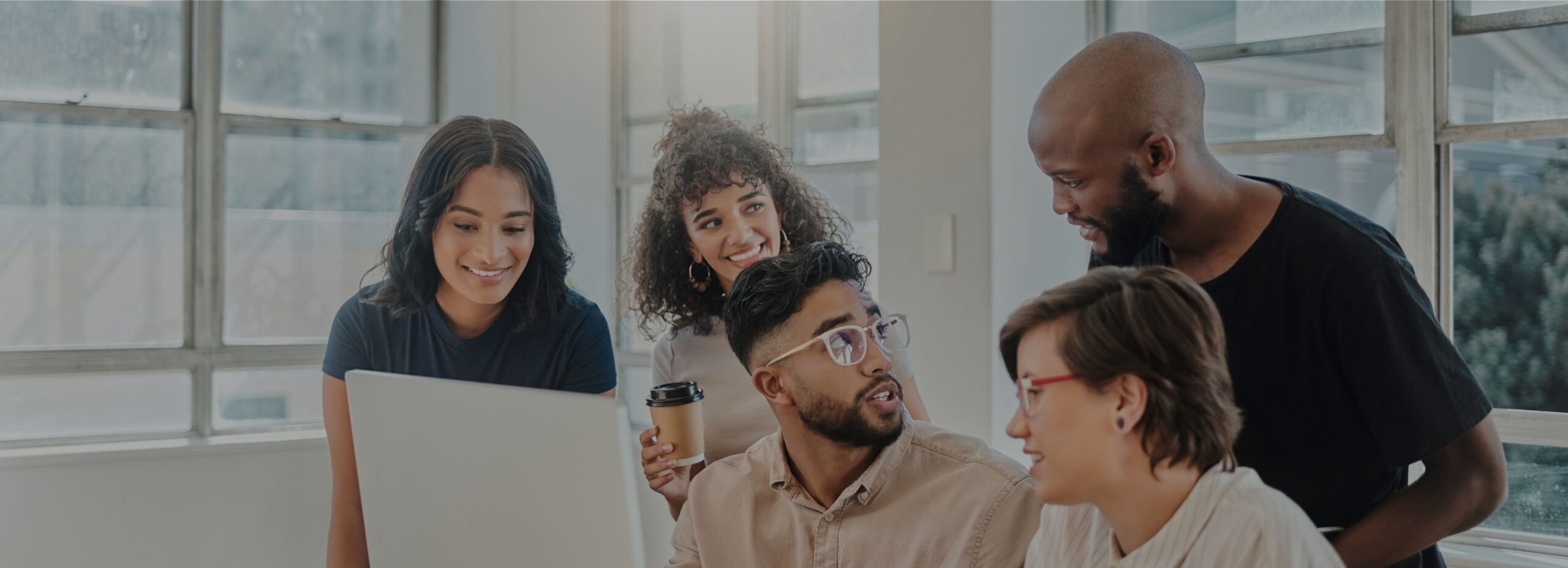 Culture - A group of diverse people around a computer chatting with each other